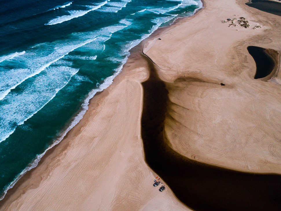 Blacksmiths Beach drone photography: river on the beach